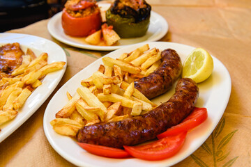Grilled sausage served with fries on plate.Typical fast food dish