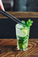 Close up view of fresh summer non alcoholic mojito cocktail on the wooden table