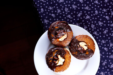 Three yummy homemade chocolate covered marshmallow crackers on white plate on a purple napkin
