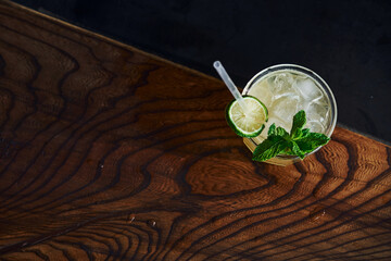 Green mint and yellow lime. Close up view of fresh summer cocktail on the wooden table