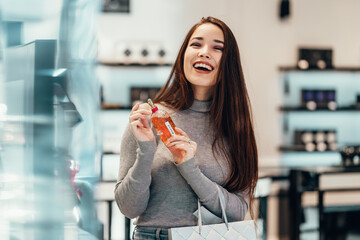 beautiful smiling Asian girl chooses buys cosmetics in the store during the day. shopping....