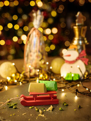 Pistachio candies on the background of the Christmas tree italian pistachio candies lying on a toy sled