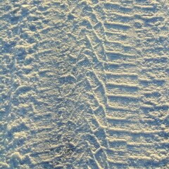 Tire tracks left in the snow on a bright sunny day