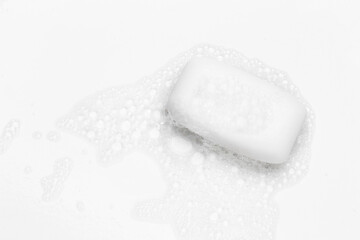 Soap bar and foam on white background