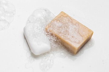 Soap bar and foam on white background