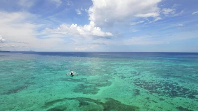 Aerial view of outrigger boat on turquoise ocean waters around Boracay Island, Western Visayas, Philippines. 