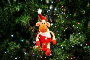 Christmas bull toy Santa sitting on the green Christmas tree