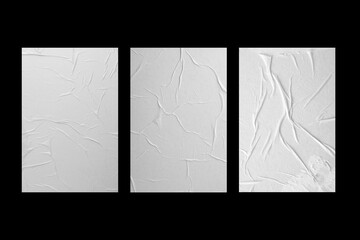 Three white sheets of paper with folds isolated on a black background.