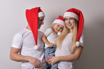 Obraz premium happy couple and baby in Christmas hats