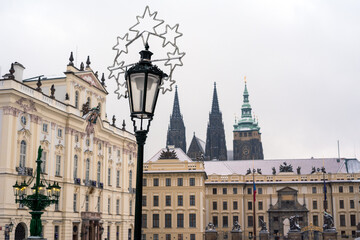 Obraz premium Classic fairytale winter view on old Prague over snow capped roofs, Christmas time in Czech Republic. 