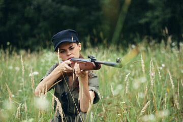 Woman on outdoor Sitting on the grass weapon in the hands of a sight hunting fresh air