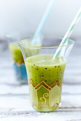 Green smoothie topped with chia seeds on bright wooden background. Close up. 