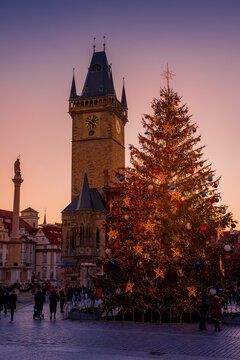 Prague, The Czech republic: A low angle view of the Old Town Square Clock Tower in the winter. The Christmas Tree and people can be seen. 