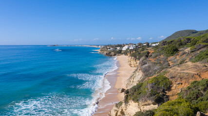 Fototapeta premium Aerial perspectives of a south Spanish beach in Andalusia with turquoise blue water. Andalusian Atlantic beach background. Ocean in Caños de Meca, Cádiz, Andalusia, Spain.