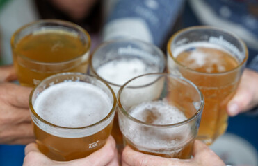 cheerful company with glasses of beer in their hands