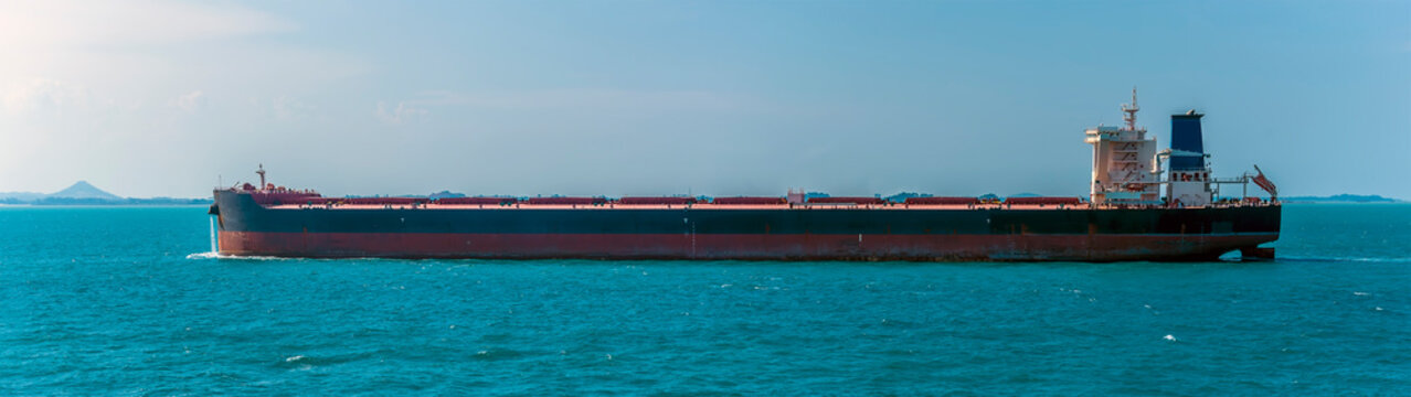 A large lightly loaded oil tanker sailing in the Singapore Straits in Asia in summertime