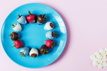 Strawberries in chocolate on a blue plate and pink background, dessert for Valentine's Day, romance, food gift. Homemade red strawberries in chocolate. Postcard with a romantic dessert with free space