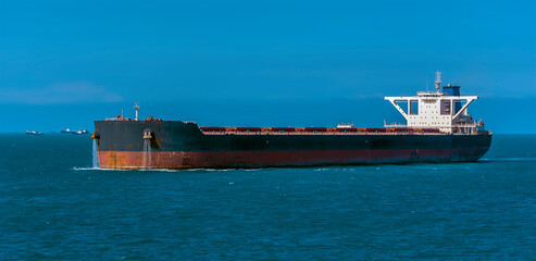 A close-up view of a large lightly loaded oil tanker sailing in the Singapore Straits in Asia in...