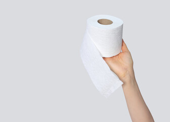 Woman hand holding toilet paper on gray background