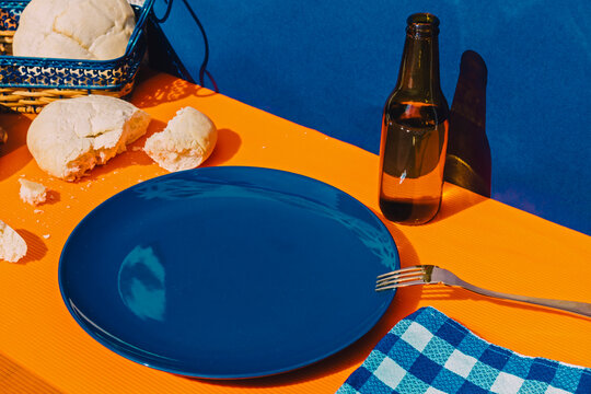 Bread, bottle of beer and empty plate