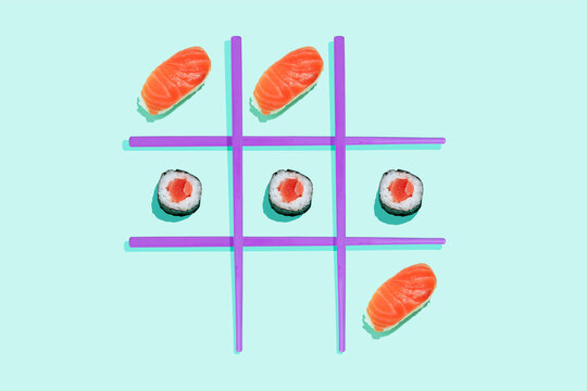 Tic-tac-toe game with salmon sushi maki and nigiri with purple chopsticks on mint green background