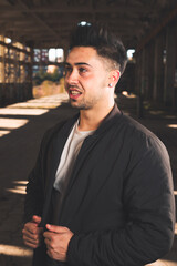 Fototapeta premium Young caucasian man posing in a abandoned pavilion.