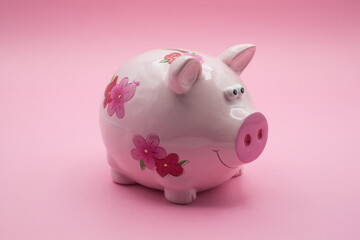 Closeup of pink flowers piggy bank on front view on pink background