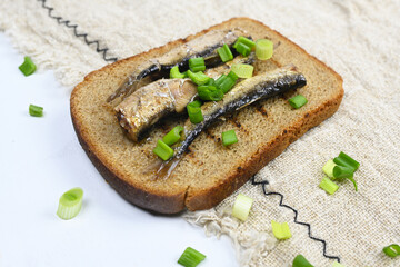 Sandwich with sprats on wooden table. Top view.