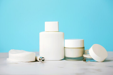Fototapeta na wymiar Skincare products.Cream jars,lotion, exfoliating cream and a cotton discs