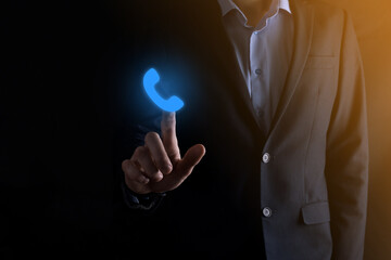 Businessman in suit on black background clicks on phone icon.Call Now Business Communication...