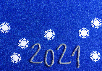 2021 and snowflakes on a blue shiny background. Christmas, winter, new year  composition. Top view.