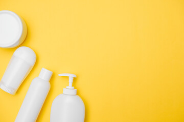 personal hygiene product white jars on a yellow background, copy space, top view