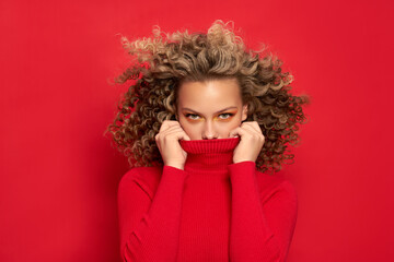 beautiful young girl in a red jacket on a red background with a new year mood