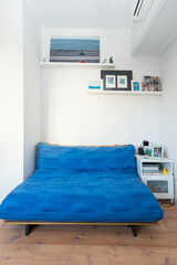 Nice room with a blue sofa and a white bedside table