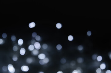 Abstract pattern of white bokeh lights on black background