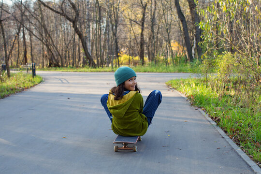 Stylish skateboarder in autumn park