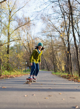 Stylish skateboarder in autumn park