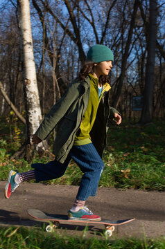 Stylish skateboarder in autumn park