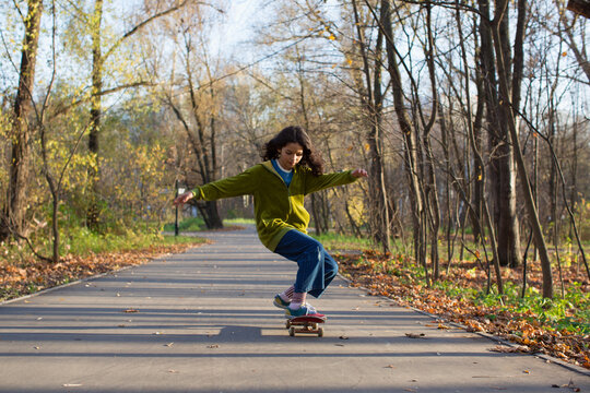 Stylish skateboarder in autumn park