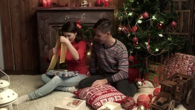 Happy couple packing the presents at home. Relationship, family, christmas, new year, holiday concet.