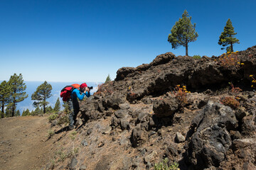 man hiking and photographing volcanic nature on canary islands