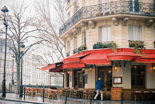 unrecognizable old man running into a Parisian cafe