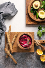 Healthy organic vegan spread made of beet and avocado with gluten free bread sticks