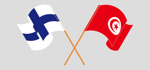 Crossed and waving flags of Finland and Tunisia