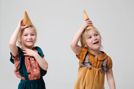 Two sweet girl-twins have fun together in a studio