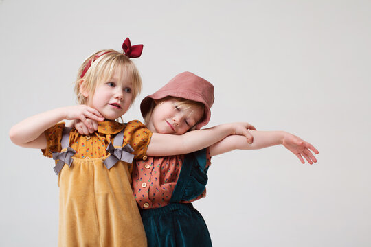 Two cute and little twins dancing in a studio