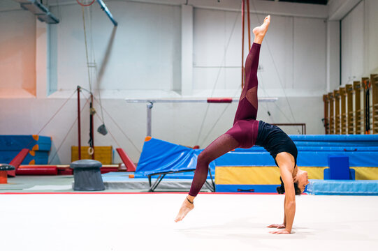 young artistic gymnast woman performing and training somersaults