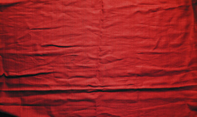 Red textured vibrant cloth with folds. Abstract backdrop. Wallpaper. Mock up.