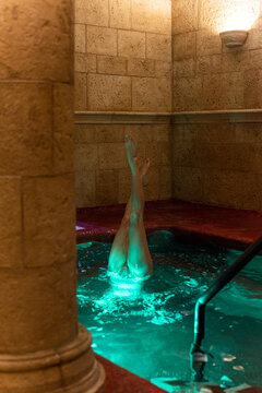 Woman doing underwater headstand in pool