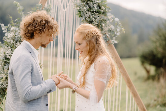 bride puts a wedding ring on her bridegroom